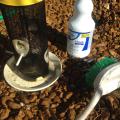 Bird feeder, bottle of bleach and cleaning brush.