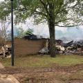 Smoke rises from a mostly burned structure.