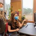 Two women work in an office setting.