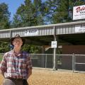 A man stands outside a structure.