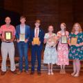 A group of people holding awards.