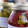 A glass jar with a metal lid is full of vegetables.