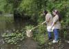 Breanna Lyle of Aberdeen uses a net to collect water insects during an insect and plant camp at Mississippi State University, while her twin sister, Deanna Lyle, waits with a bucket to take them back to campus for identification. Insect collecting is a favorite activity at the annual summer camp. (Photo by Scott Corey)