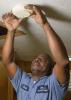 Russell Carroll, a maintenance supervisor with the Canton Housing Authority in Canton, Mississippi, checks batteries in a smoke detector in one of the housing units he services. Carroll participated in a Healthy Homes Initiative training and shares information with his colleagues and clients to help them improve their environments. (File photo by MSU Extension Service/Kevin Hudson)