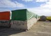 Picked cotton sits in large green and red bales.