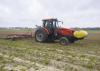 Man on a tractor plants corn.