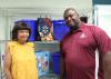 A woman and a man pose in front of shopping bags and blue crates.